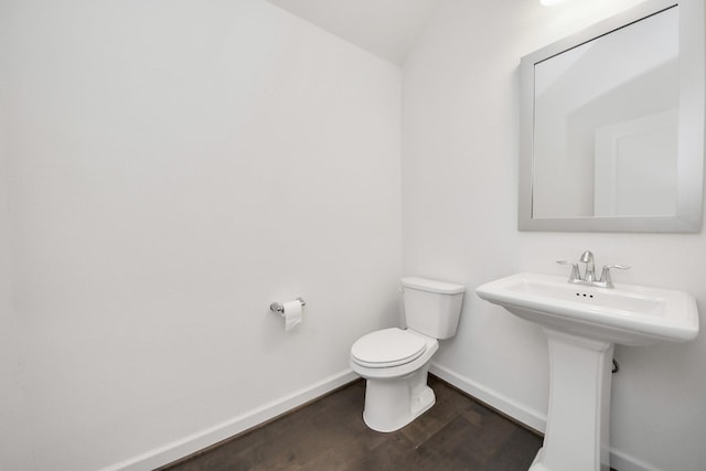 bathroom with wood finished floors, toilet, and baseboards