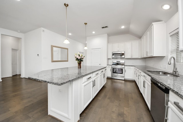 kitchen featuring light stone counters, a sink, stainless steel appliances, white cabinets, and visible vents