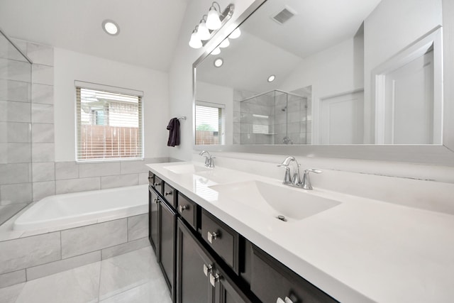 bathroom with vaulted ceiling, tiled bath, a sink, and a stall shower