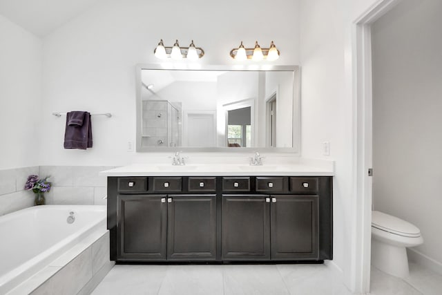 full bathroom with a bath, a sink, double vanity, and a stall shower