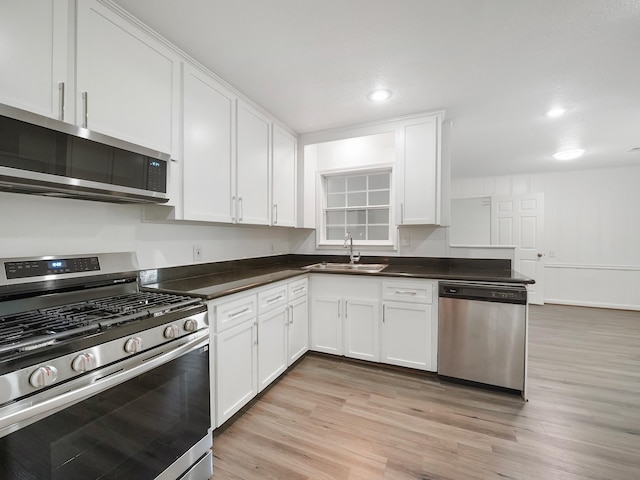 9710 Bassoon Dr, Houston, TX 77025 - kitchen featuring white cabinets, stainless steel appliances, a sink, and light wood-type flooring