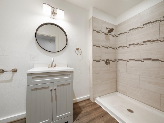 9710 Bassoon Dr, Houston, TX 77025 - full bath featuring baseboards, wood finished floors, vanity, and tiled shower