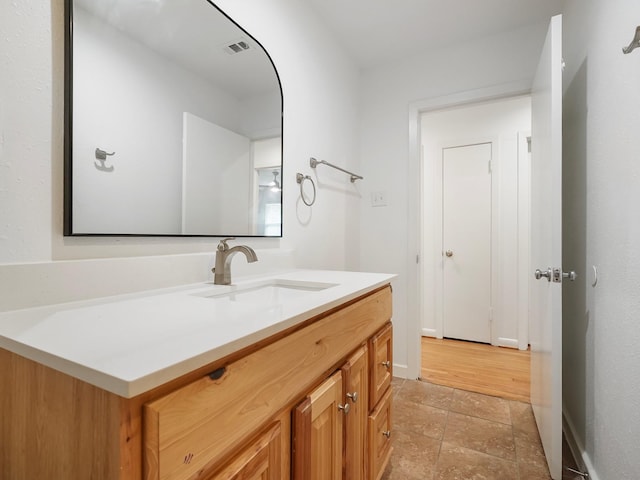 9710 Bassoon Dr, Houston, TX 77025 - bathroom with stone finish flooring, baseboards, vanity, and visible vents