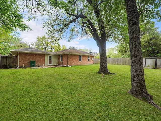 9710 Bassoon Dr, Houston, TX 77025 - view of yard with a fenced backyard and an outbuilding