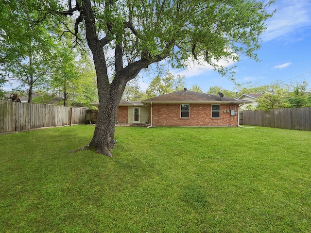 9710 Bassoon Dr, Houston, TX 77025 - back of house featuring a fenced backyard, brick siding, and a lawn