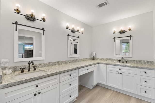 6310 Wickwillow Ln, Alvin, TX 77511 - bathroom with double vanity, wood finished floors, visible vents, and a sink