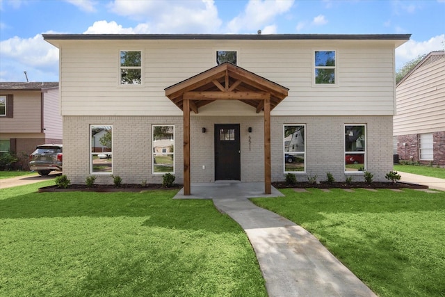 view of front of home featuring a front lawn and brick siding