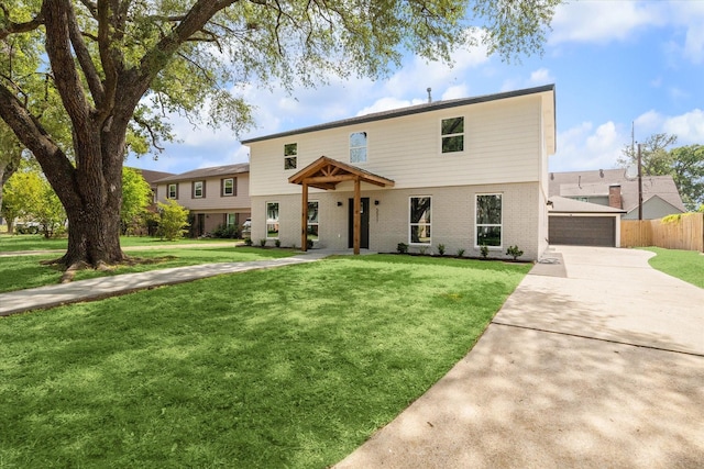 view of front of home with brick siding, a front lawn, fence, and a garage