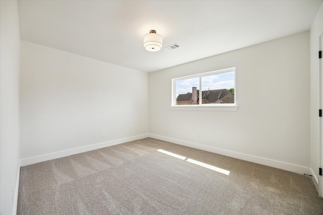 empty room featuring baseboards, carpet flooring, and visible vents