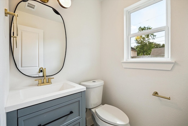 bathroom featuring visible vents, vanity, and toilet