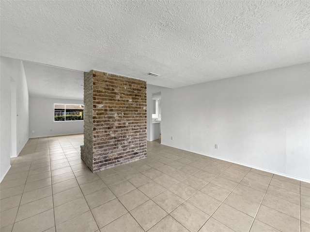unfurnished room featuring light tile patterned flooring, a textured ceiling, and visible vents