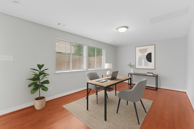 office featuring visible vents, baseboards, and wood finished floors