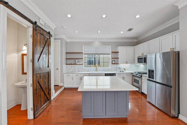 1646 W 13th St, Houston, TX 77008 - kitchen featuring stainless steel appliances, open shelves, a barn door, a sink, and light countertops