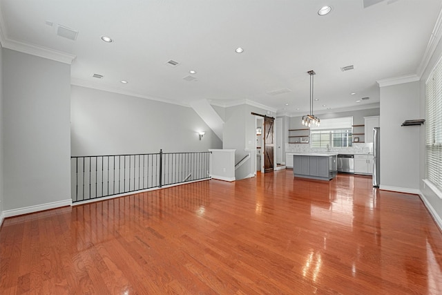 1646 W 13th St, Houston, TX 77008 - unfurnished living room featuring a barn door, baseboards, wood finished floors, recessed lighting, and ornamental molding