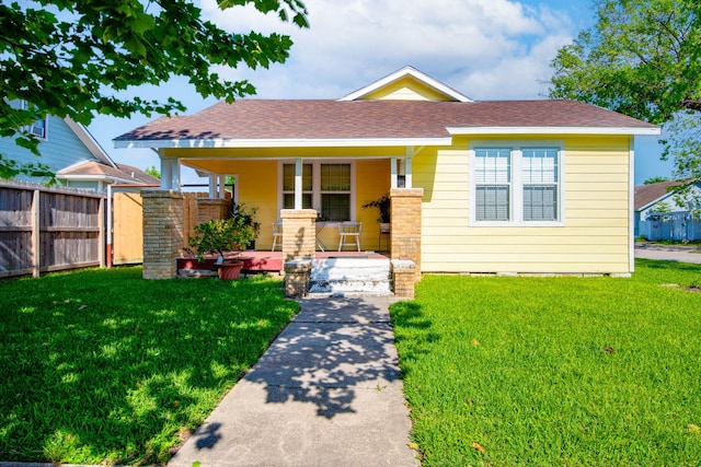 611 N Gaillard St, Baytown, TX 77520 - view of front of home featuring fence, a shingled roof, a front lawn, and covered porch