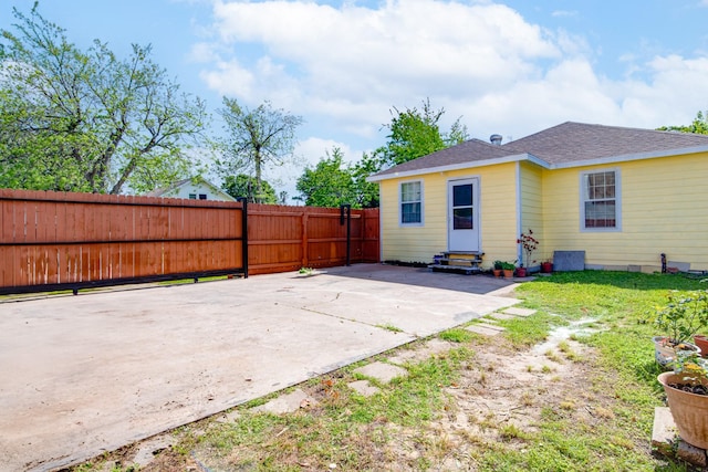 611 N Gaillard St, Baytown, TX 77520 - rear view of house featuring roof with shingles, fence, entry steps, a patio area, and a lawn