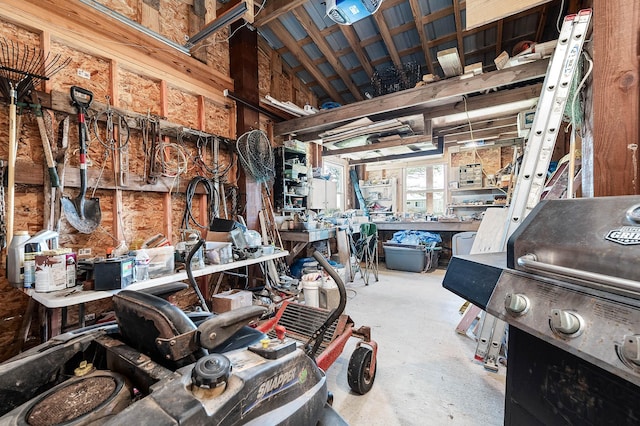 miscellaneous room with concrete flooring and a workshop area