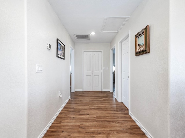 corridor featuring baseboards, wood finished floors, visible vents, and recessed lighting