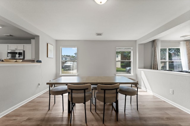 dining area featuring wood finished floors, visible vents, and plenty of natural light