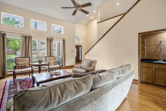 13018 Lentando Ln, Cypress, TX 77429 - living room featuring a towering ceiling, a ceiling fan, light wood-style flooring, recessed lighting, and baseboards