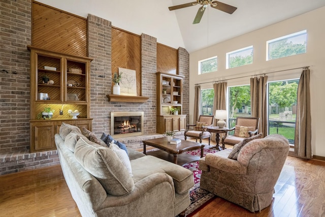13018 Lentando Ln, Cypress, TX 77429 - living area with high vaulted ceiling, a ceiling fan, wood finished floors, a brick fireplace, and wooden walls