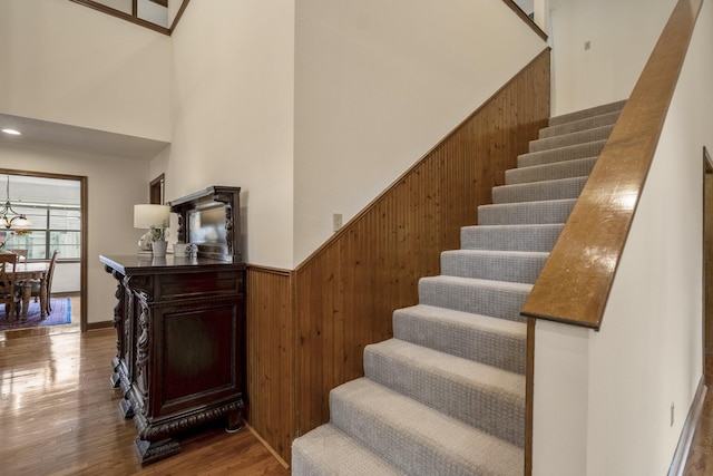 13018 Lentando Ln, Cypress, TX 77429 - stairs with wood walls, a high ceiling, wood finished floors, and wainscoting