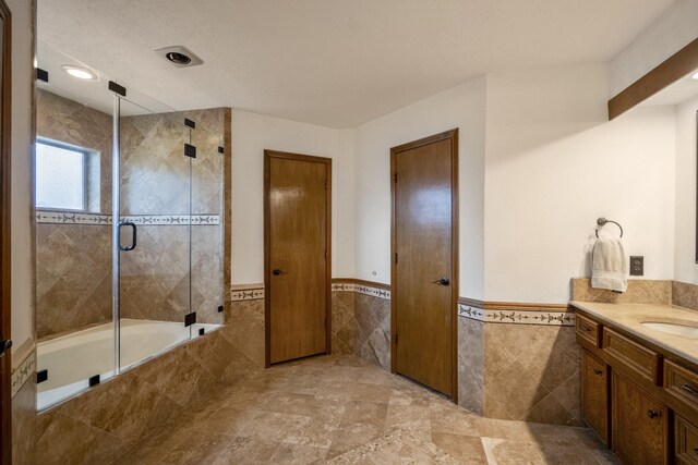 13018 Lentando Ln, Cypress, TX 77429 - full bathroom with tile walls, vanity, tiled shower / bath, and wainscoting