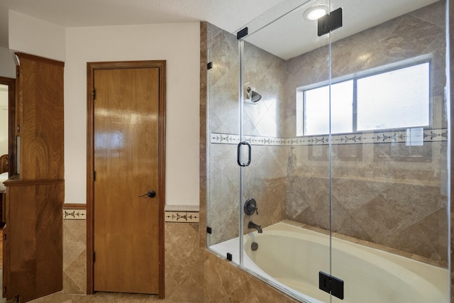 13018 Lentando Ln, Cypress, TX 77429 - bathroom with tiled shower / bath combo, tile walls, and a wainscoted wall