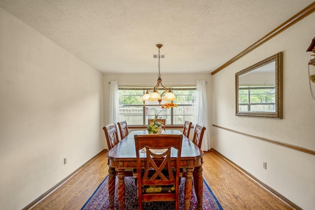 13018 Lentando Ln, Cypress, TX 77429 - dining space featuring a textured ceiling, light wood-style flooring, a chandelier, baseboards, and ornamental molding