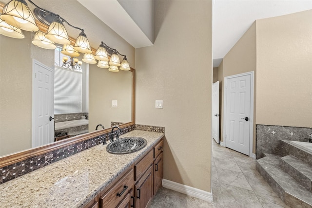 bathroom featuring vanity, a garden tub, baseboards, and a chandelier