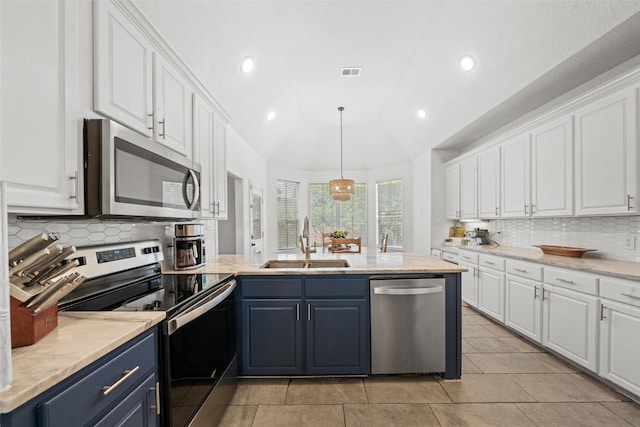 kitchen with white cabinetry, appliances with stainless steel finishes, a sink, and blue cabinetry