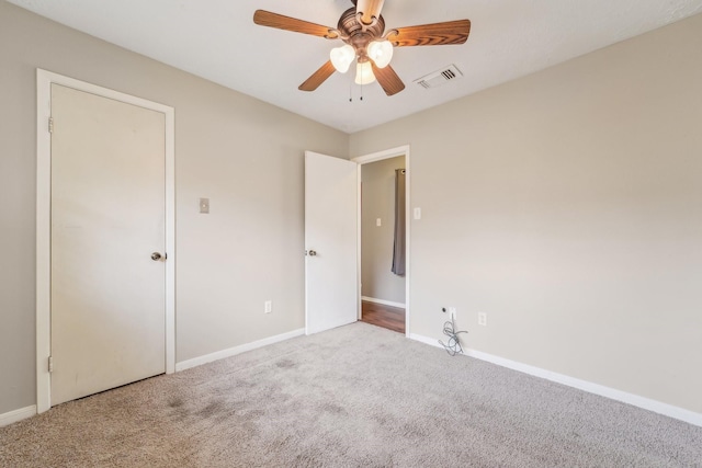 unfurnished bedroom featuring baseboards, visible vents, carpet flooring, and ceiling fan