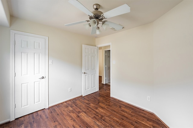 unfurnished bedroom featuring baseboards, visible vents, ceiling fan, and dark wood-type flooring