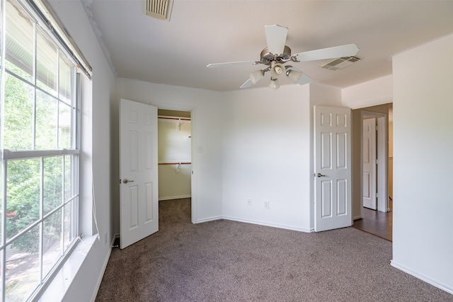 unfurnished bedroom with visible vents, carpet, and a walk in closet
