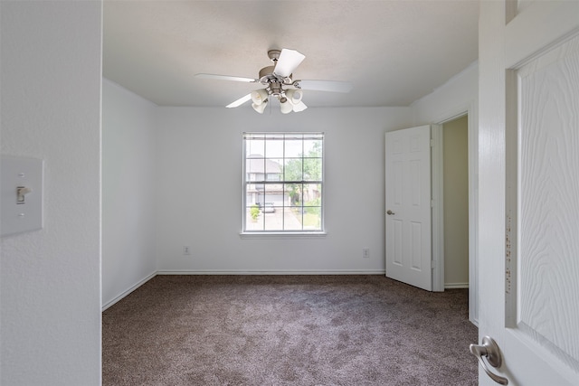 spare room featuring baseboards, ceiling fan, and carpet