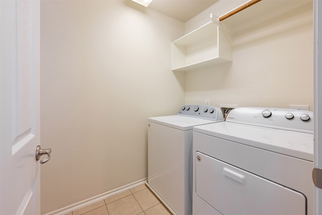 washroom featuring light tile patterned floors, baseboards, laundry area, and independent washer and dryer