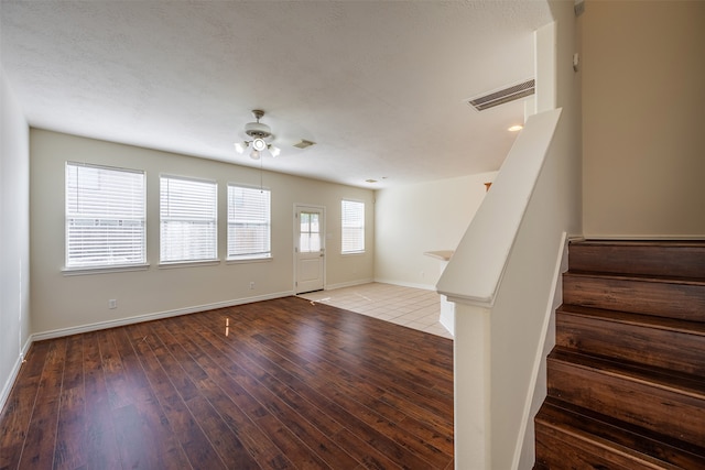 entryway with stairway, visible vents, baseboards, and hardwood / wood-style flooring