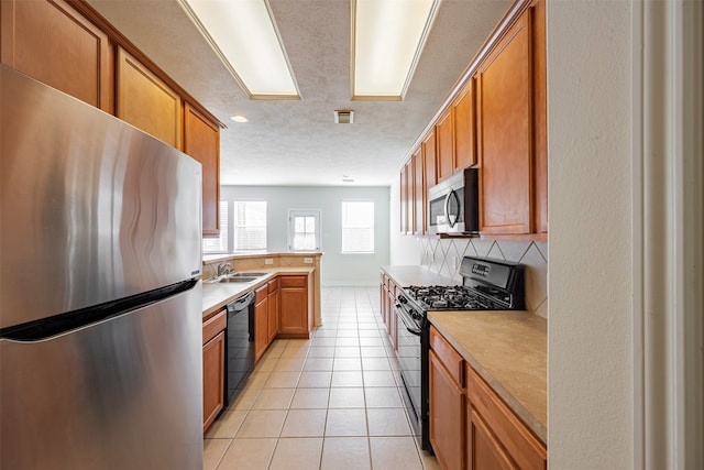 kitchen with visible vents, light countertops, decorative backsplash, and black appliances