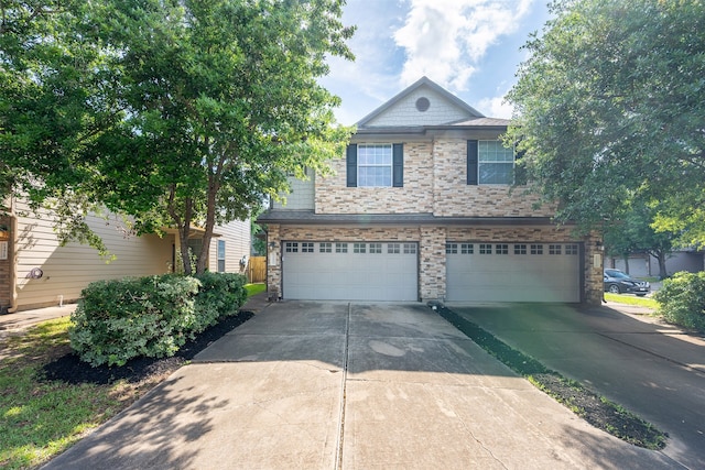view of front facade with a garage, concrete driveway, and stone siding
