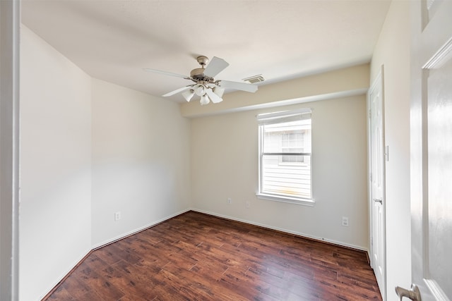 unfurnished room featuring dark wood-style flooring, ceiling fan, and visible vents
