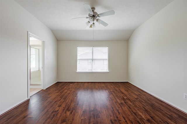 empty room featuring baseboards, a ceiling fan, vaulted ceiling, and wood finished floors
