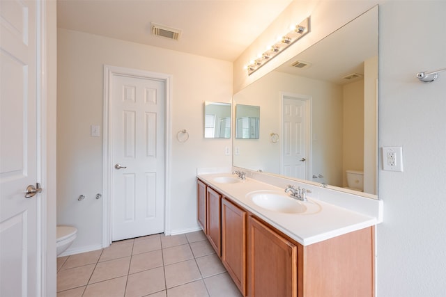 bathroom with toilet, visible vents, a sink, and tile patterned flooring