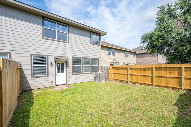 rear view of house featuring a lawn, a fenced backyard, and cooling unit