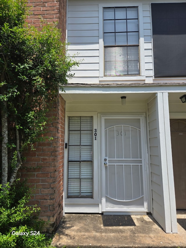 view of exterior entry featuring brick siding