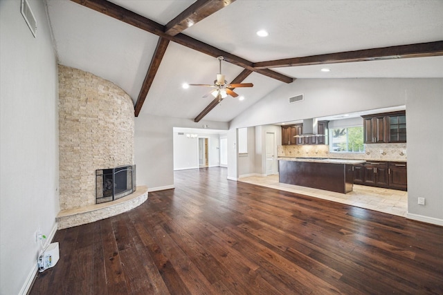 unfurnished living room featuring light wood-style floors, ceiling fan, a stone fireplace, baseboards, and recessed lighting