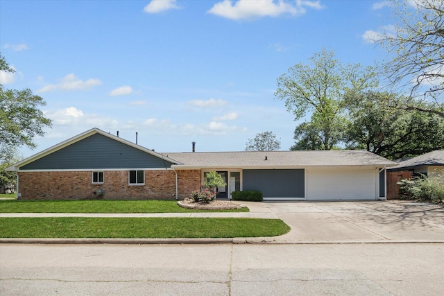 view of front facade featuring concrete driveway, a front yard, and brick siding