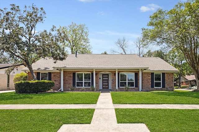 single story home featuring a front yard, brick siding, and a shingled roof