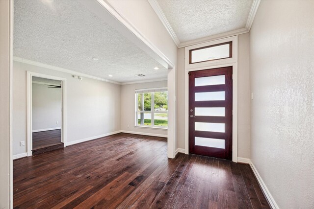 foyer with a textured ceiling, dark wood finished floors, baseboards, and ornamental molding