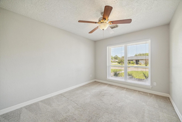 unfurnished room featuring carpet, ceiling fan, baseboards, and a textured ceiling