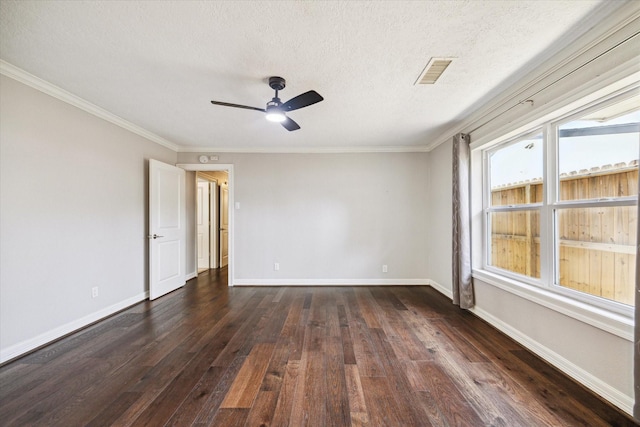 empty room featuring dark wood-type flooring, a ceiling fan, a textured ceiling, ornamental molding, and baseboards